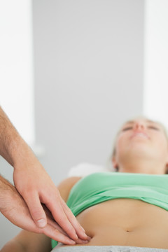物理治疗师为女人做腹部检查