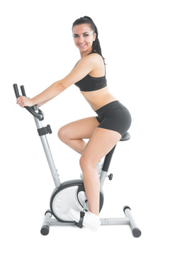 微笑的女人骑着健身车