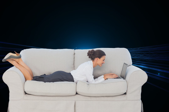 女人躺在沙发上使用笔记本电脑