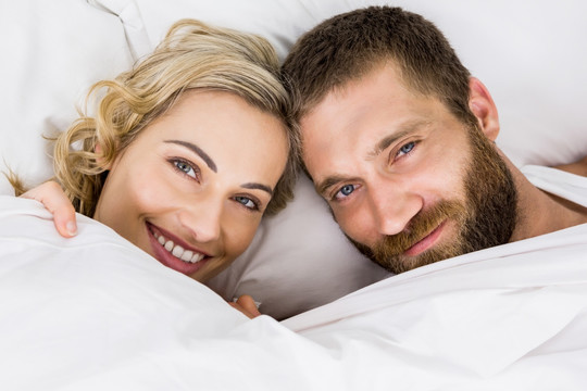 躺在床上微笑的一对夫妇
