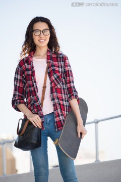 微笑的女人拿着一个滑滑板