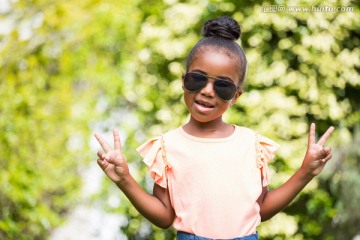 在公园里戴着太阳眼镜的小女孩