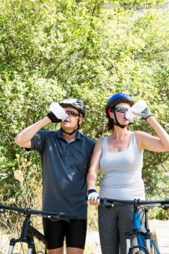 站在自行车旁喝水的夫妇