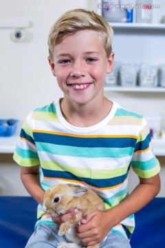 微笑着抱着兔子的男孩