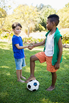 微笑着握手踢足球的孩子
