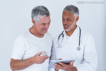 微笑着看着平板电脑的医生和病人