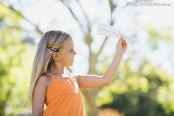 年轻女孩在公园里玩纸飞机
