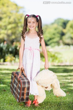 抱着一个手提箱和玩具熊的女孩