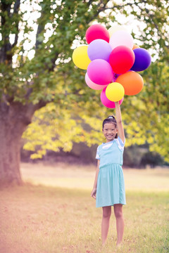 拿着气球泡在公园里的小女孩