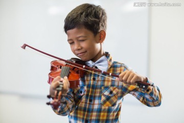 在教室里拉小提琴的男学生