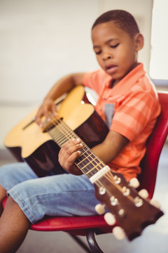 在教室里弹吉他的男孩
