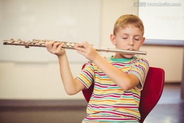 在教室里吹长笛的男学生