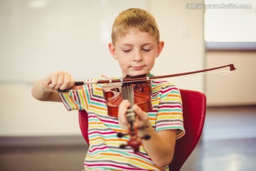 在教室里拉小提琴的男学生