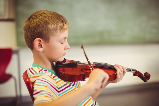 小学生在教室里拉小提琴
