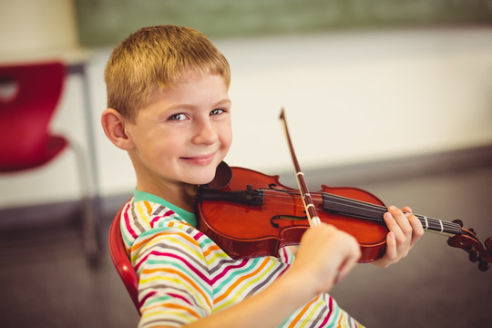微笑着拉小提琴的小学生
