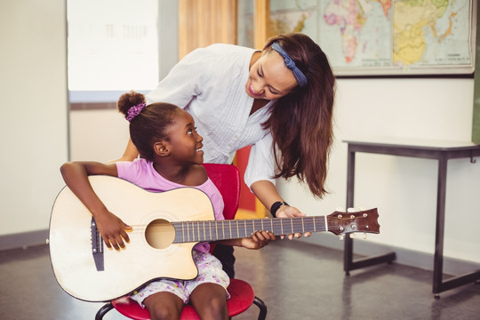老师教一个女孩弹吉他