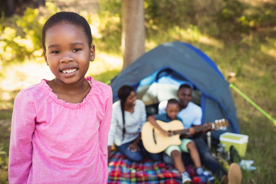 微笑的女孩和家人在外露营