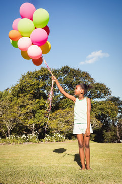 在公园里拿着气球泡的小女孩