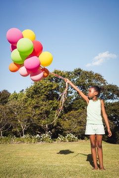 在公园里拿着气球泡的小女孩