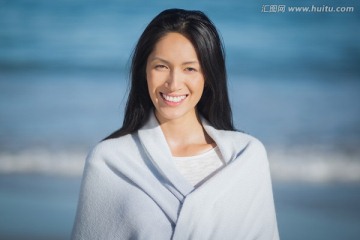 在海边披着毛巾的女人