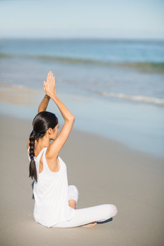 坐在沙滩上练习瑜伽的女人