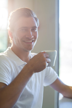 微笑的男人在喝一杯咖啡