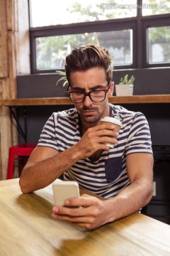 在咖啡馆里使用手机的男人