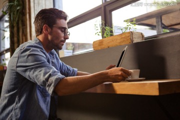 坐着使用平板电脑的男人