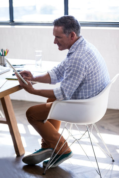 坐着使用平板电脑的商务男人