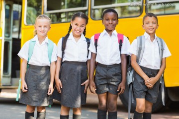 微笑的孩子们站在校车旁