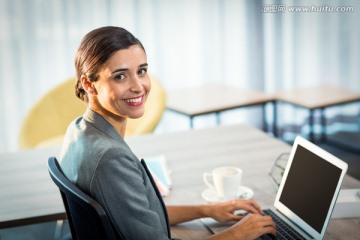 微笑着使用笔记本电脑的商务男女
