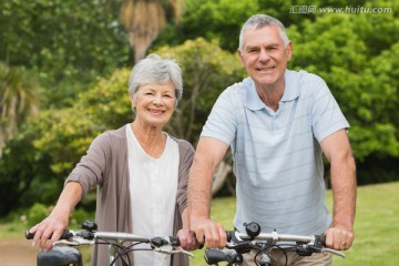 在公园骑自行车的一对老年夫妇