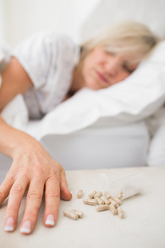 一个成熟的女人吃药丸睡觉