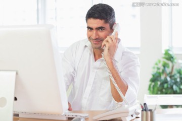 看着电脑打电话的商务男人