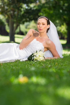躺在草坪中献飞吻的新娘
