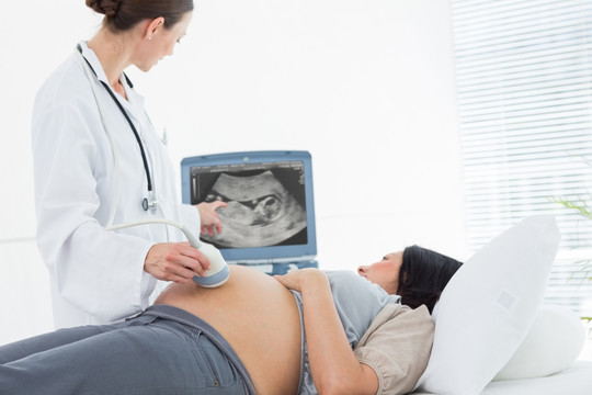 女医生在给孕妇做超声检查