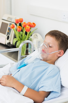 躺在病床上戴氧气面罩的病人