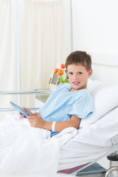 坐在病床上使用平板电脑的病人