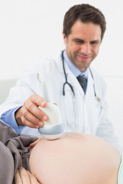 微笑的孕妇在医院接受超声检查