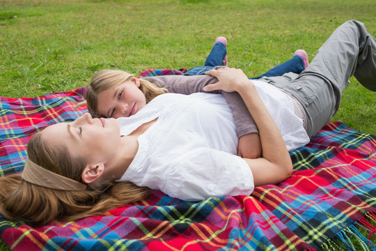 躺在公园野餐巾上的一对母女