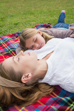 躺在公园野餐巾上睡觉的母女