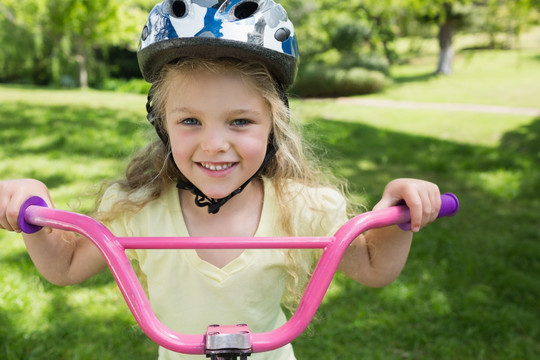 在公园骑自行车的小女孩