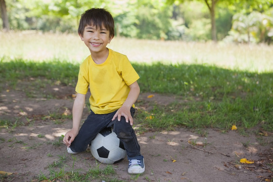 可爱的小男孩在公园里玩足球