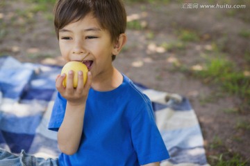 可爱的小男孩在公园里吃水果