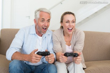 在客厅里玩游戏机的夫妇