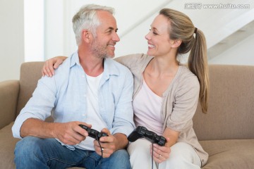 在客厅里玩游戏机的夫妇
