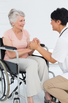医生和坐在轮椅上的病人握手