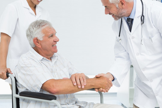 老年患者和医生在医务室握手