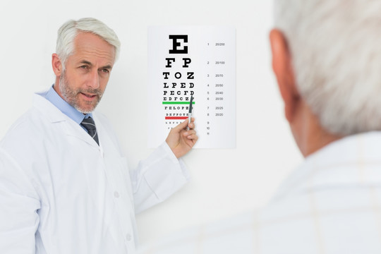 给老年患者指着视力表的眼科医生