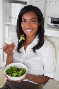 微笑着吃蔬菜沙拉的女人